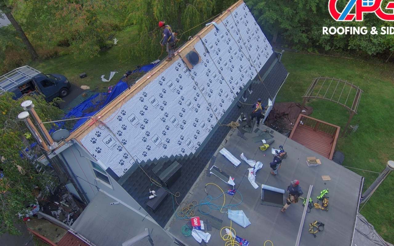 Technician applying protective roof coating to a flat surface
